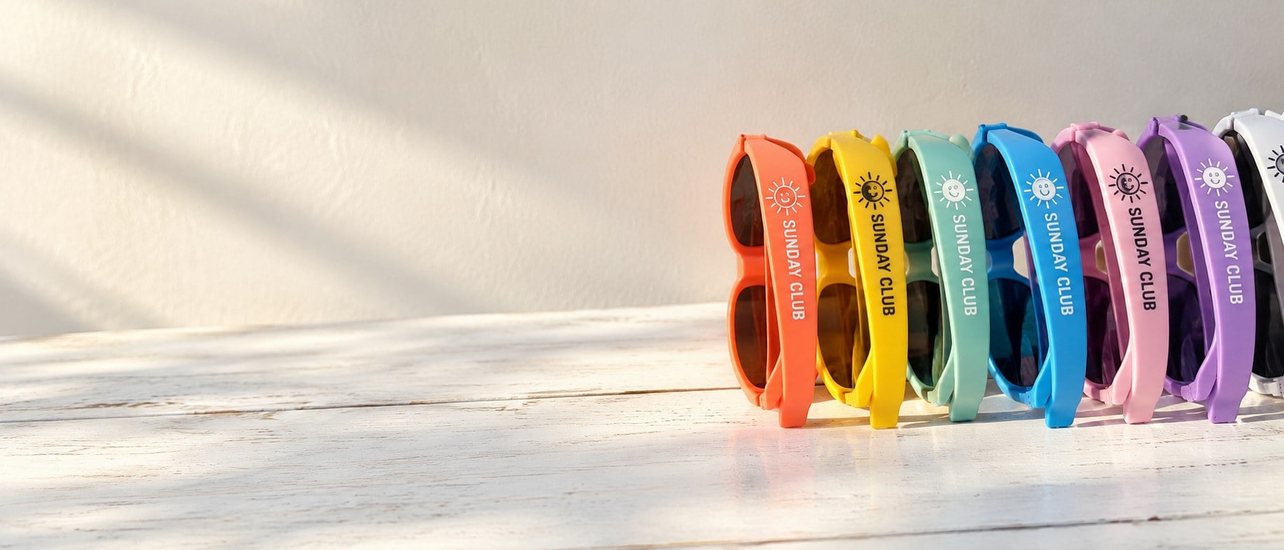 Custom logo sunglasses in bulk lined up on a sunny table